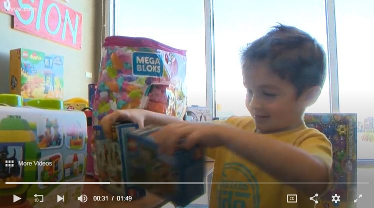 Little boy picks up his choice of toys from the giant pile at Ronald McDonald House