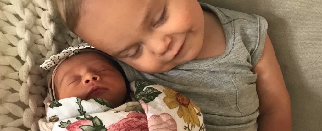young child sleeping closely with newborn sibling