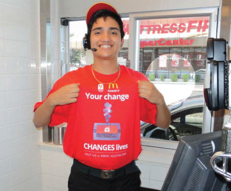smiling mcdonalds employee with a shirt promoting change donations